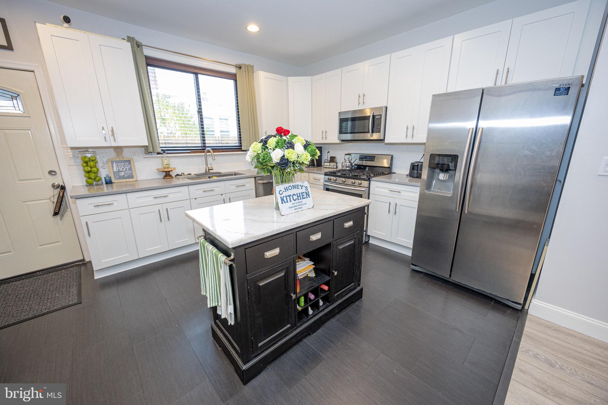 6113 Ross Street Philadelphia, PA 19144 - Photo 14 of 40 a kitchen with stainless steel appliances a sink a stove a refrigerator cabinets and a window