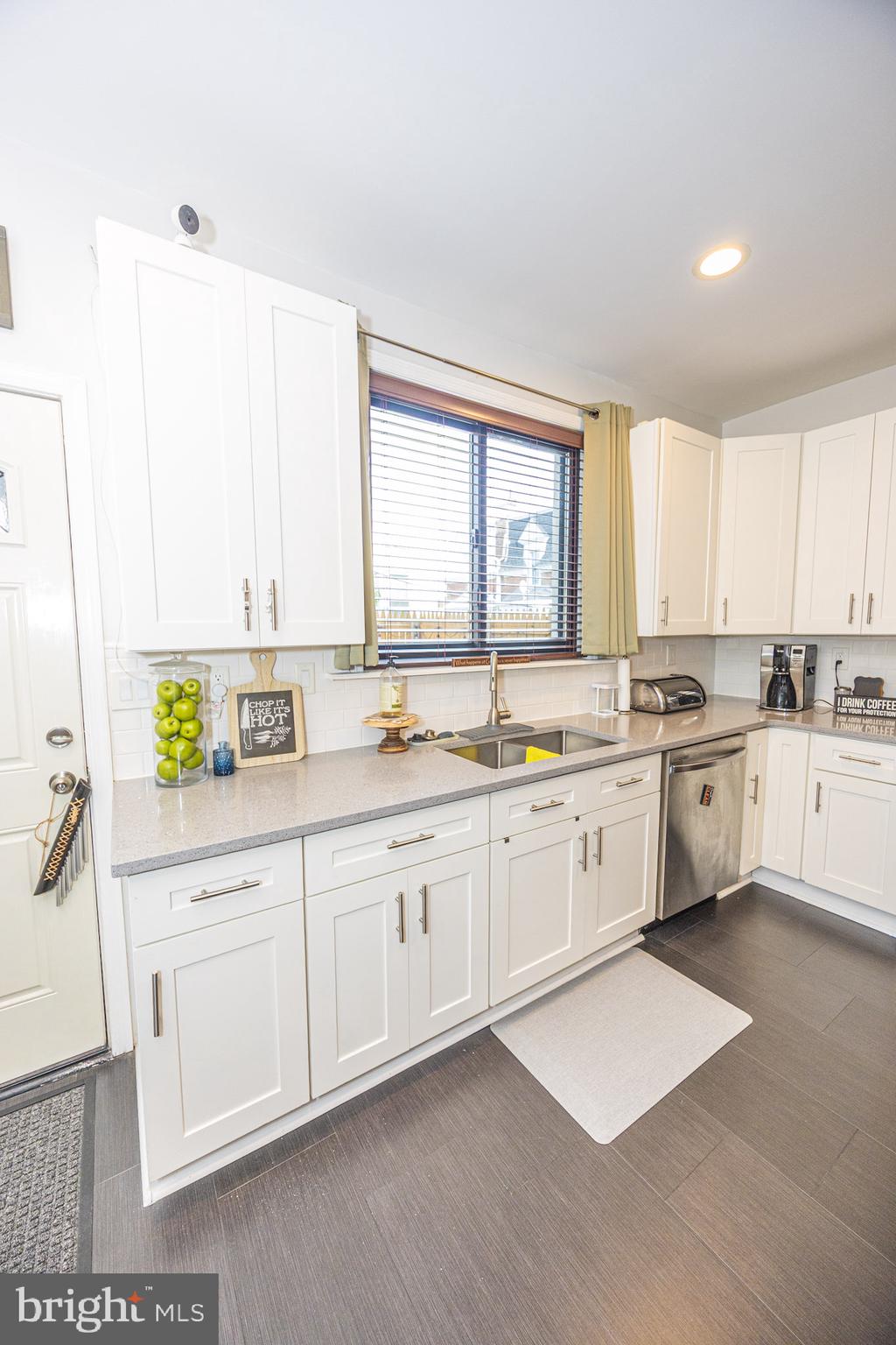 6113 Ross Street Philadelphia, PA 19144 - Photo 16 of 40 a large white kitchen with stainless steel appliances granite countertop a stove a sink a window and white cabinets