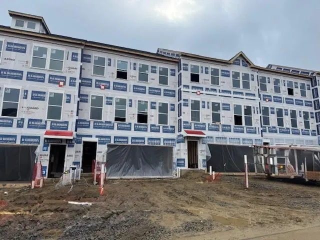 a front view of a building with glass windows and a street