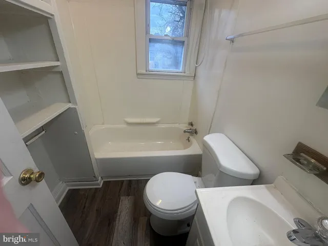 a white toilet sitting next to a bathroom sink and tub