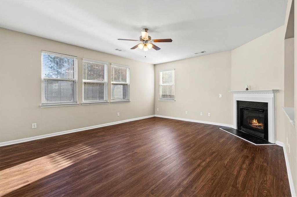 125 Parkmont Court Dallas, GA 30132 - Photo 11 of 36 a view of an empty room with wooden floor fireplace and a window