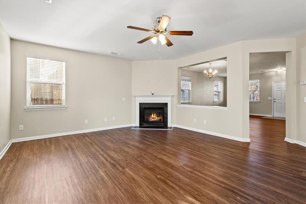 125 Parkmont Court Dallas, GA 30132 - Photo 12 of 36 an empty room with wooden floor a ceiling fan and windows
