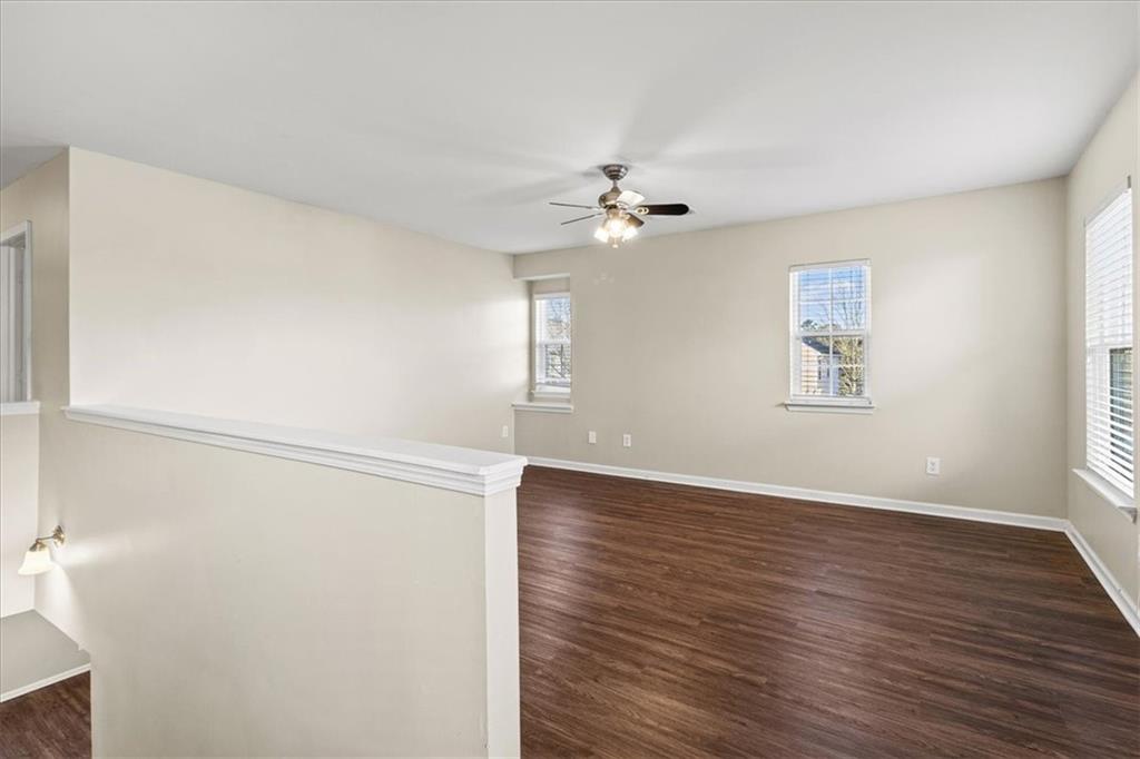 125 Parkmont Court Dallas, GA 30132 - Photo 22 of 36 an empty room with wooden floor chandelier fan and windows