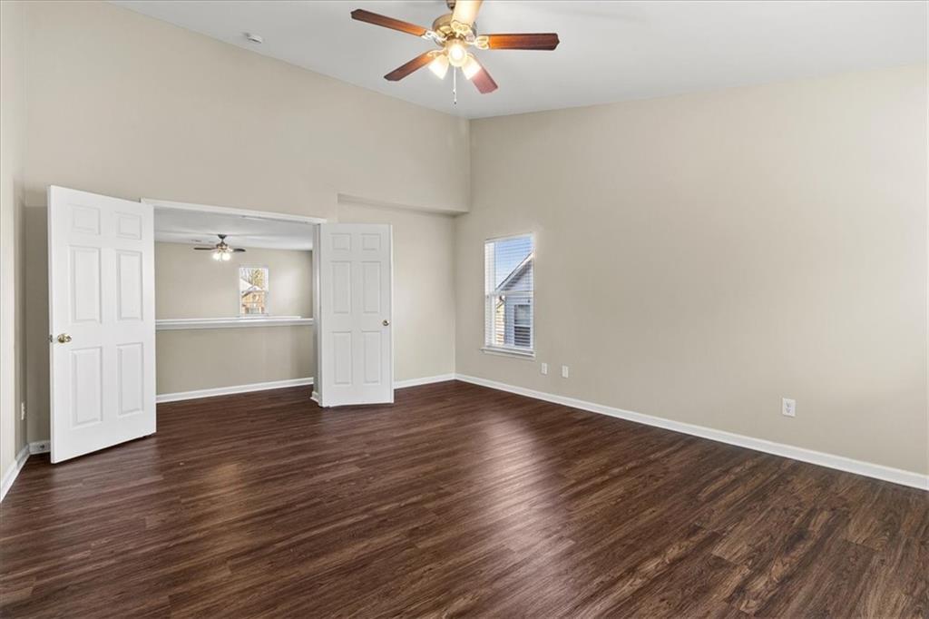 125 Parkmont Court Dallas, GA 30132 - Photo 23 of 36 an empty room with wooden floor chandelier fan and windows