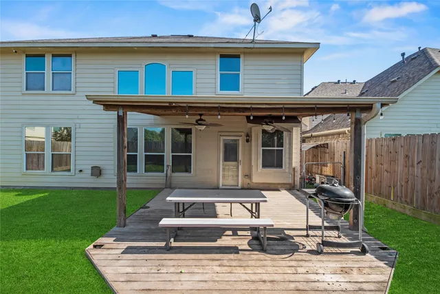 a view of a backyard with table and chairs and a barbeque