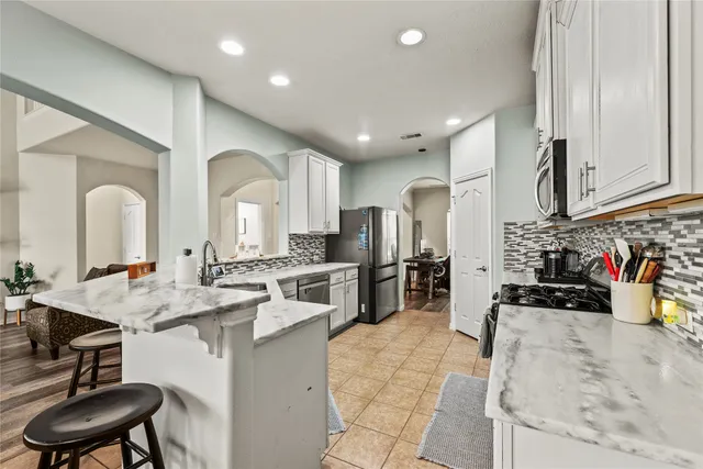 a kitchen with stainless steel appliances kitchen island granite countertop a sink and cabinets