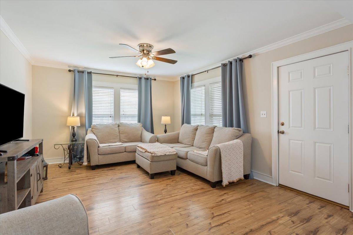 1607 North Harding Avenue Cameron, TX 76520 - Photo 8 of 37 Hardwood-style flooring extends across this spacious living area, highlighted by elegant crown molding and ample natural light.