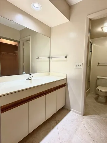 a bathroom with a double vanity sink a toilet and a mirror