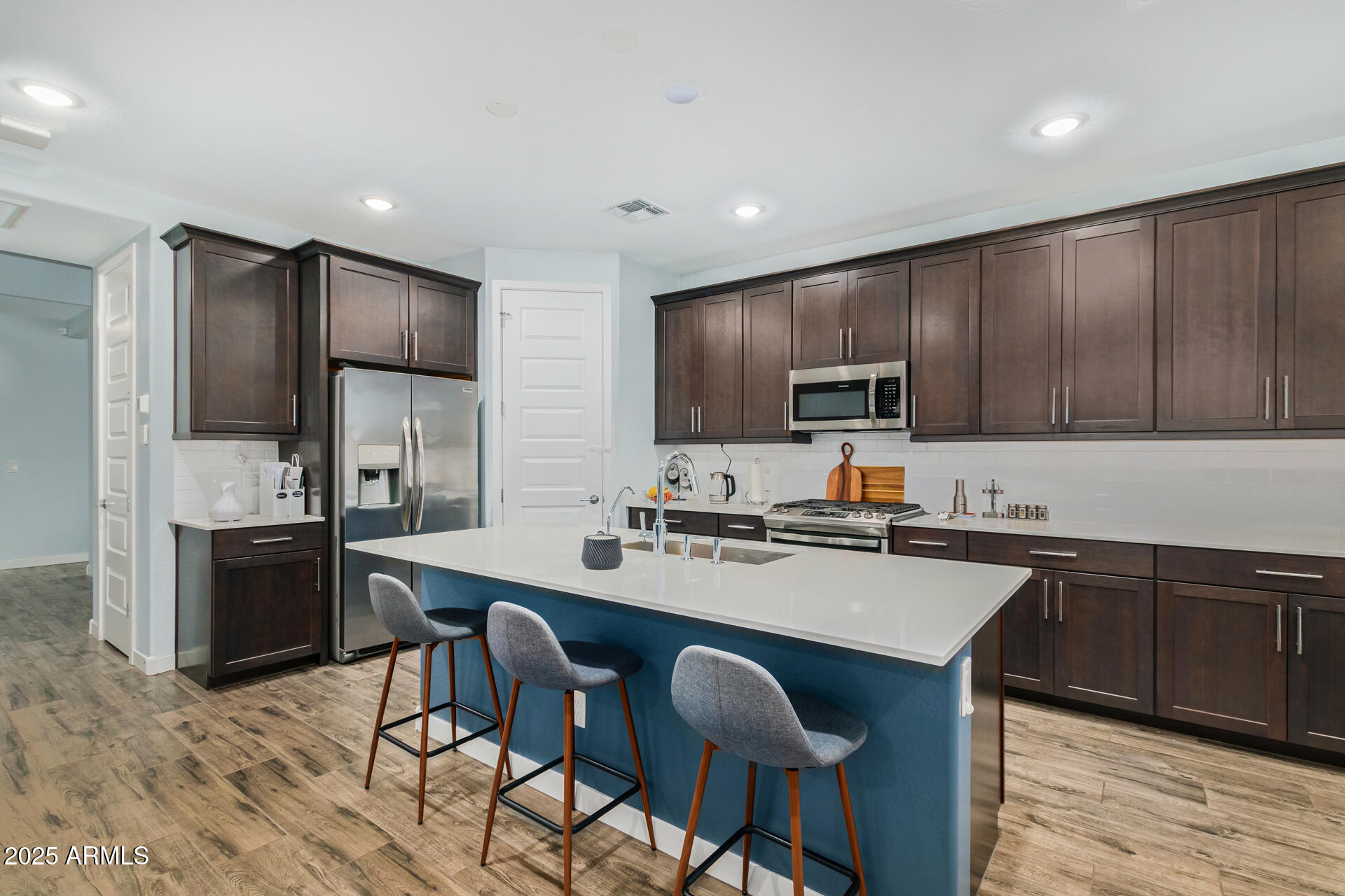 1171 East Armstrong Way Chandler, AZ 85286 - Photo 8 of 30 a kitchen with a sink a microwave a refrigerator and wooden cabinets