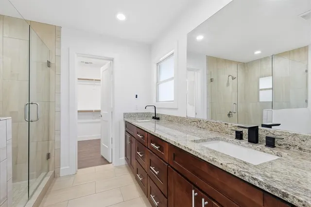 a bathroom with a granite countertop sink a toilet and shower