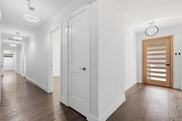 a view of a hallway with wooden floor