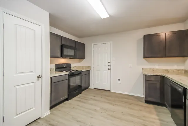 a kitchen with stainless steel appliances granite countertop a stove a sink and a refrigerator