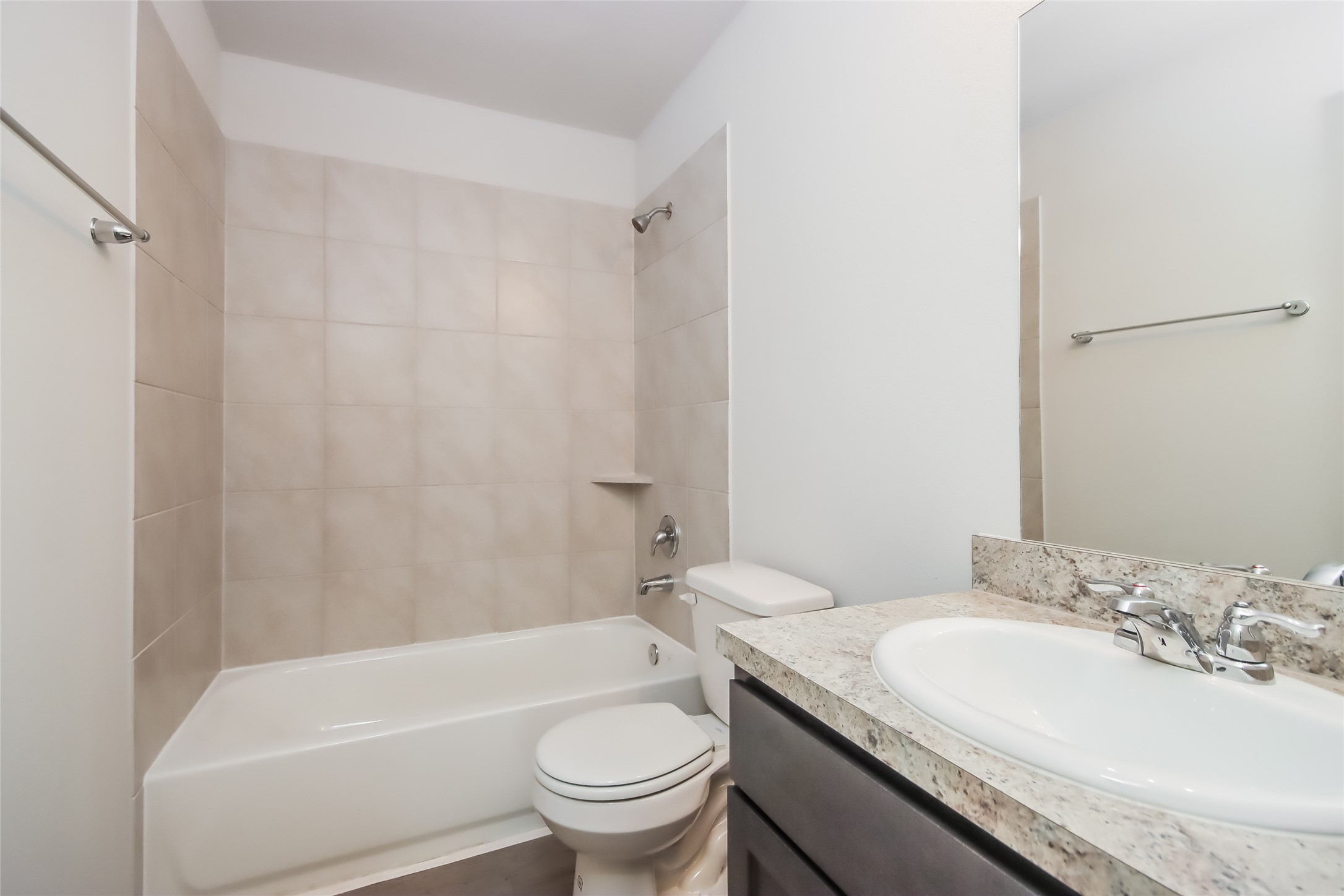 3512 Cub Court Conroe, TX 77301 - Photo 12 of 18 a bathroom with a granite countertop sink a toilet a mirror a bathtub and shower