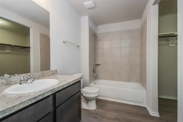 a bathroom with a granite countertop sink a toilet and shower