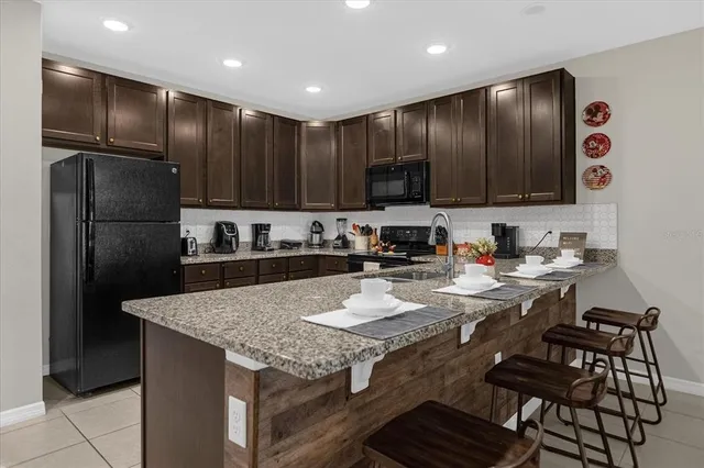 a kitchen with granite countertop stainless steel appliances a refrigerator and a sink