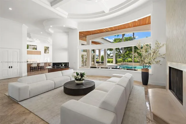 a living room with fireplace furniture and a large window