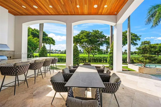 a view of a patio with table and chairs potted plants with wooden floor and fence