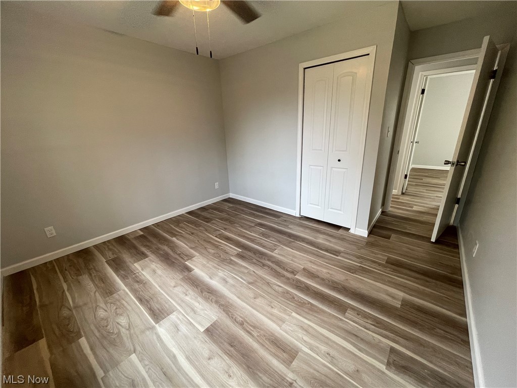 6135 California Road Williamsfield, OH 44093 - Photo 23 of 37 Unfurnished bedroom with dark hardwood / wood-style floors, ceiling fan, and a closet