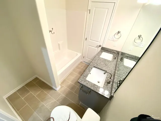 a bathroom with a granite countertop sink and a mirror