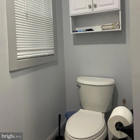 a white toilet sitting next to a window
