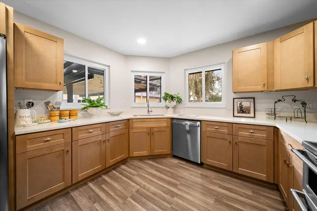 a kitchen with a sink windows and cabinets