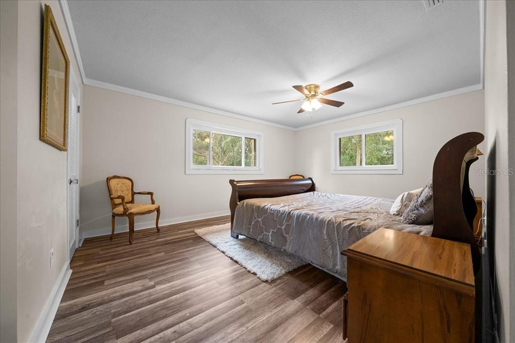 7380 Southwest 86th Lane Ocala, FL 34476 - Photo 14 of 50 a bedroom with a bed and a chandelier