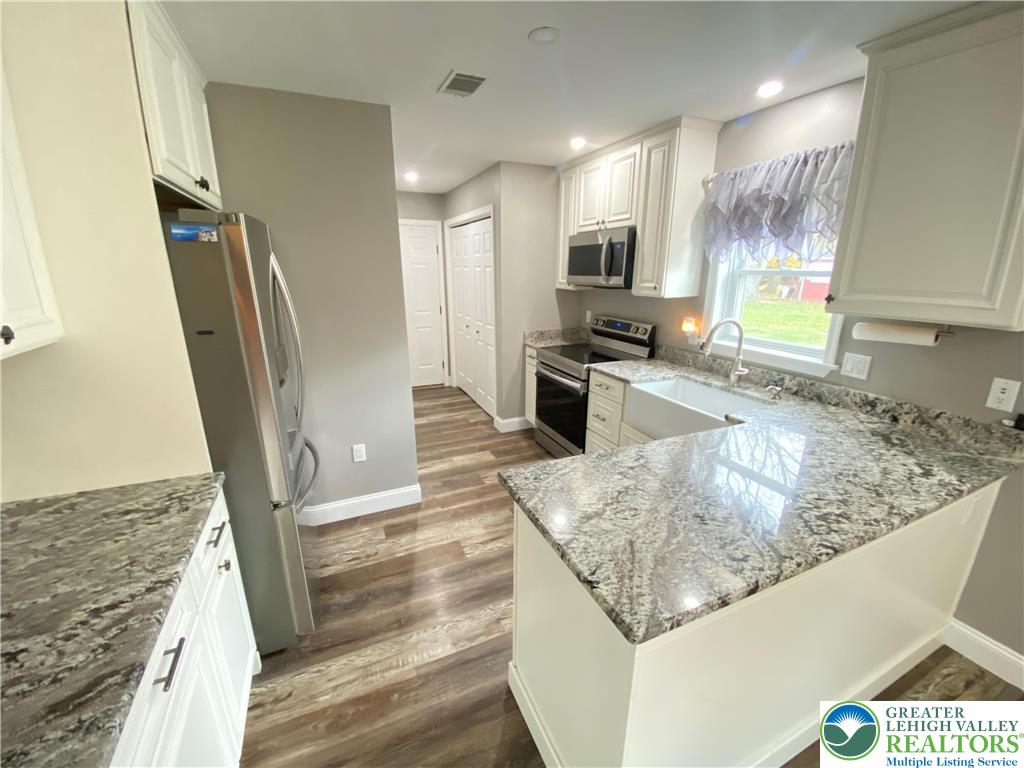 4571 Newburg Road Nazareth, PA 18064 - Photo 5 of 29 a kitchen with stainless steel appliances granite countertop sink stove refrigerator and microwave