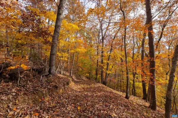 a front view of a house with a yard and mountain view in back