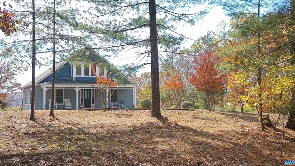 a kitchen with stainless steel appliances granite countertop a refrigerator a stove a sink a dining table and chairs with wooden floor