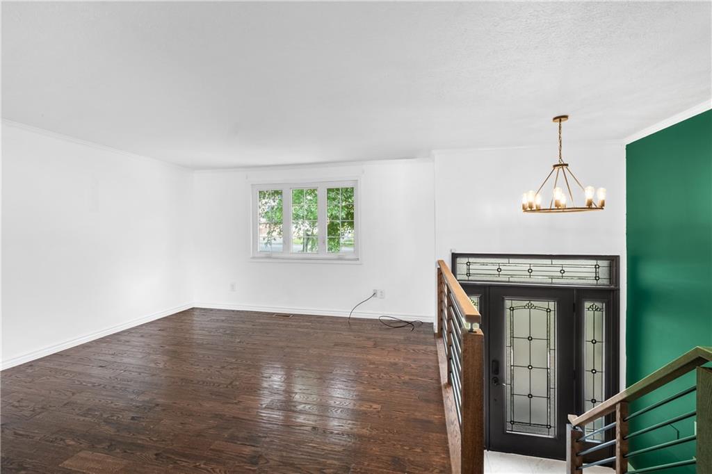 230 Dodd Drive Washington, PA 15301 - Photo 11 of 49 an empty room with wooden floor windows and a chandelier
