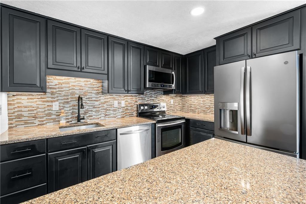 230 Dodd Drive Washington, PA 15301 - Photo 15 of 49 a kitchen with granite countertop wooden cabinets a refrigerator and a sink