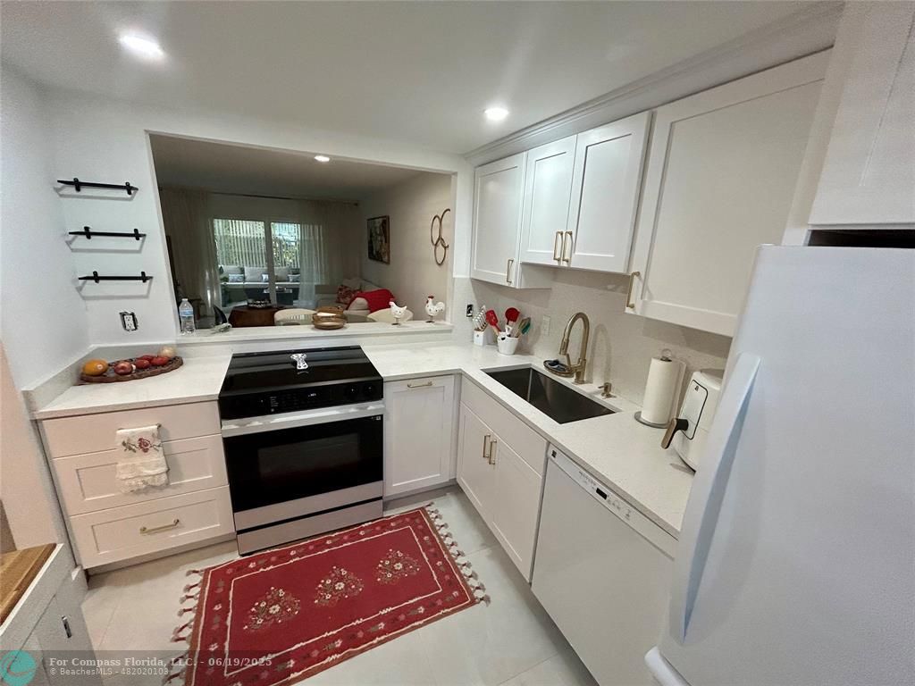 3060 Holiday Springs Boulevard, Unit 102 Margate, FL 33063 - Photo 2 of 12 a kitchen that has a sink and a stove in it