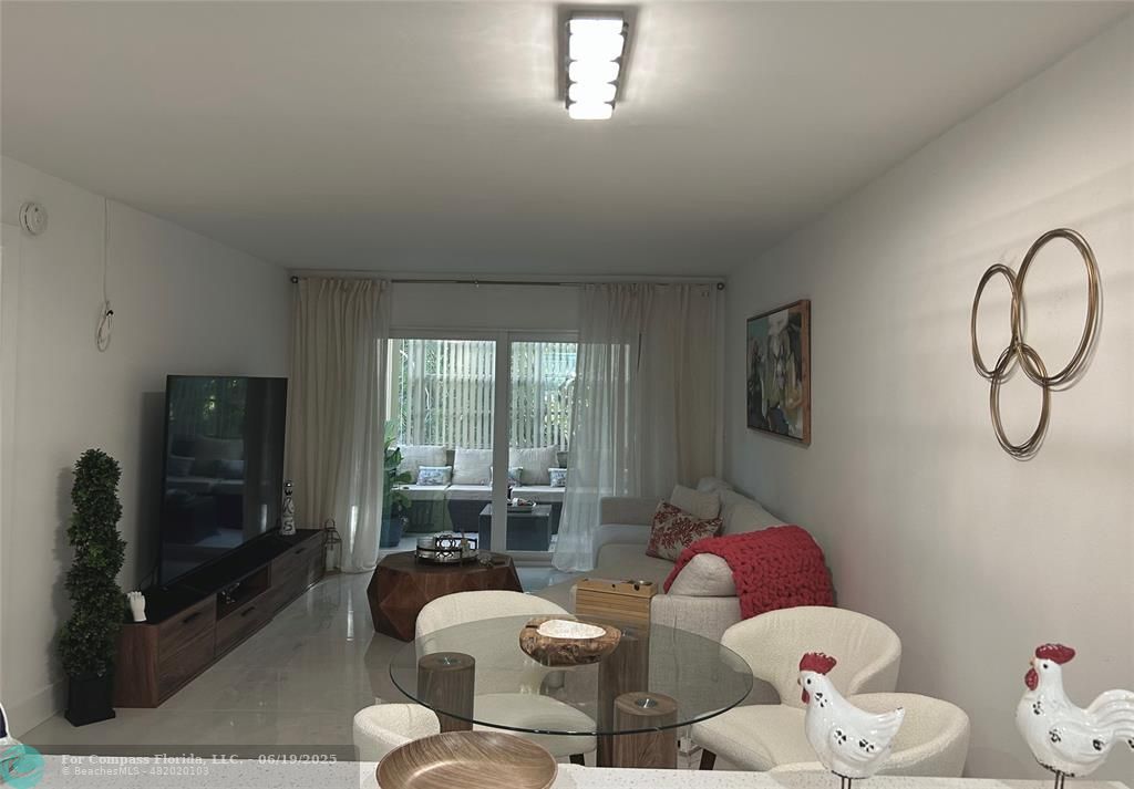 3060 Holiday Springs Boulevard, Unit 102 Margate, FL 33063 - Photo 4 of 12 a living room with furniture and a flat screen tv