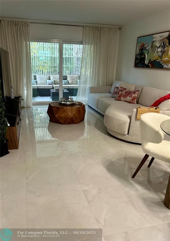 3060 Holiday Springs Boulevard, Unit 102 Margate, FL 33063 - Photo 6 of 12 a living room with furniture and a flat screen tv