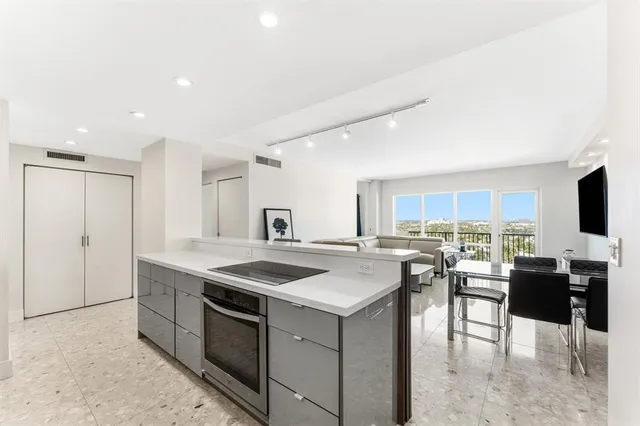 a view of a kitchen with kitchen island a sink table and chairs
