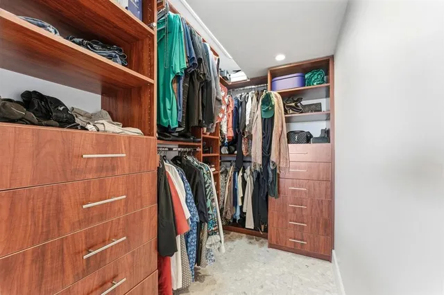 a view of walk in closet with clothes and shoes