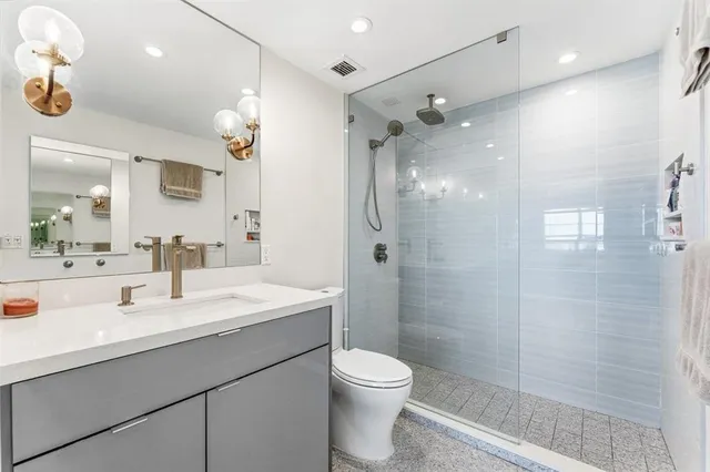 a bathroom with a sink a toilet and shower