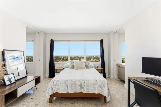 a bedroom with a bed and large window