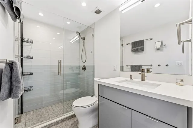 a bathroom with a sink toilet a mirror and shower