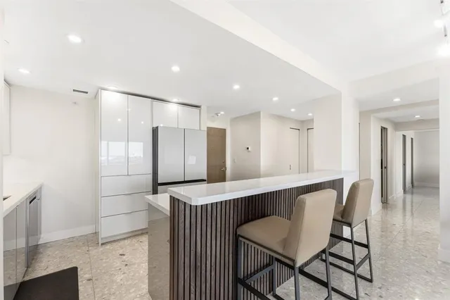 a dining hall with stainless steel appliances granite countertop a table and chairs