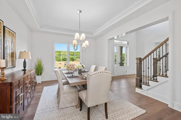 a view of a dining room with furniture a chandelier and wooden floor