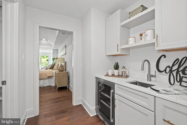 a kitchen with white cabinets and sink