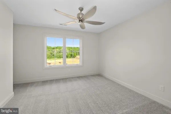 an empty room with a window and a fan