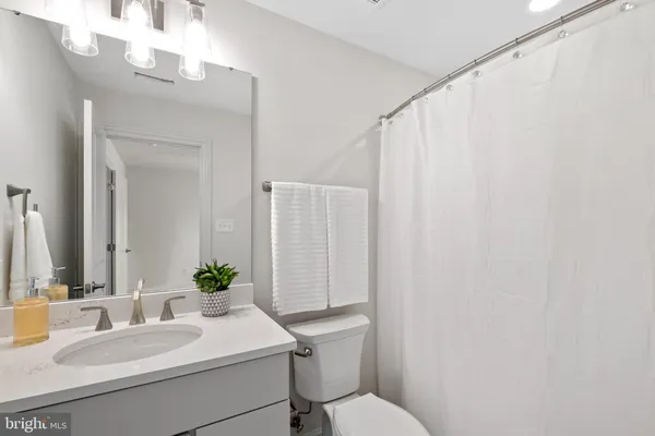 a bathroom with a sink vanity mirror and toilet