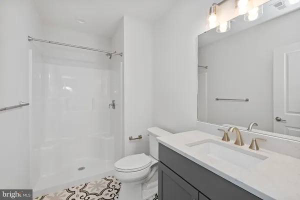 a bathroom with a sink toilet vanity and shower