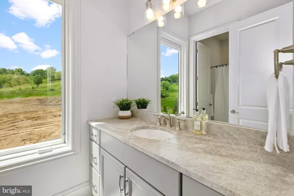 a bathroom with a granite countertop sink and a mirror