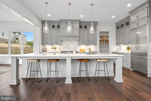 a kitchen with a table chairs sink refrigerator and cabinets