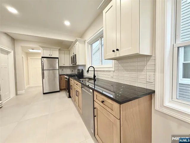 a kitchen with stainless steel appliances granite countertop a refrigerator sink and cabinets