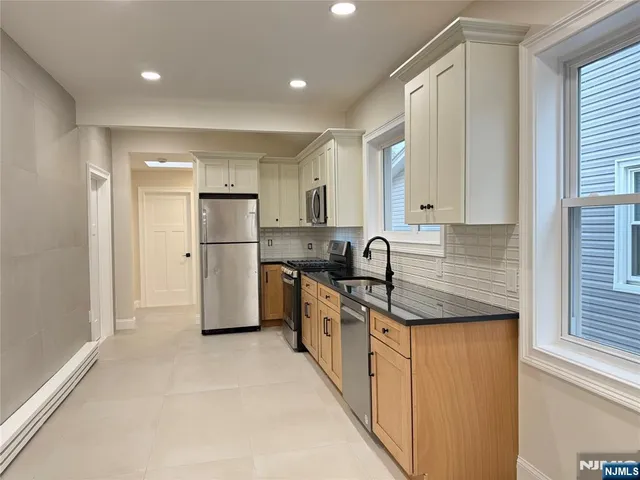 a kitchen with stainless steel appliances granite countertop a refrigerator sink and cabinets