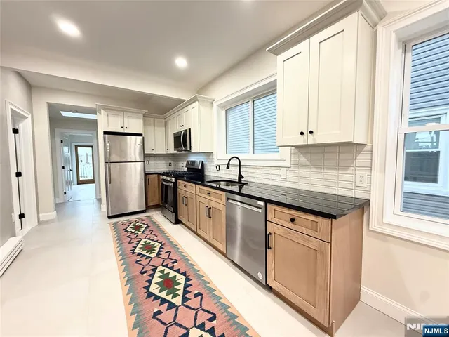 a kitchen with stainless steel appliances granite countertop a stove a sink and a refrigerator